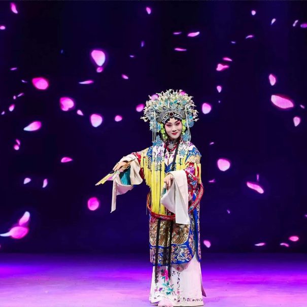 A Peking Opera actress in elaborate traditional costume and headdress performs on stage at Tianleyuan Grand Theater in Beijing.