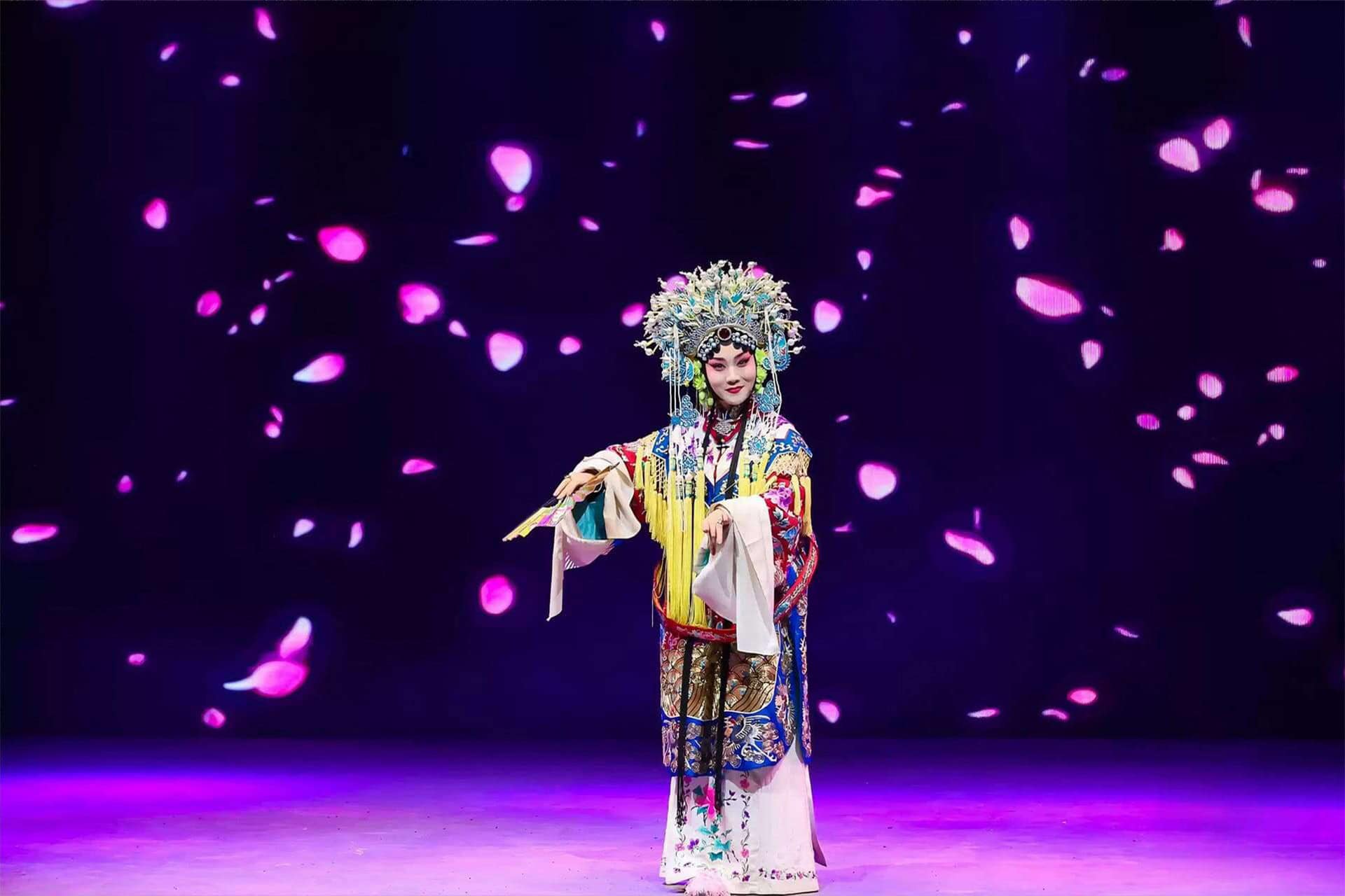 A Peking Opera actress in elaborate traditional costume and headdress performs on stage at Tianleyuan Grand Theater in Beijing.