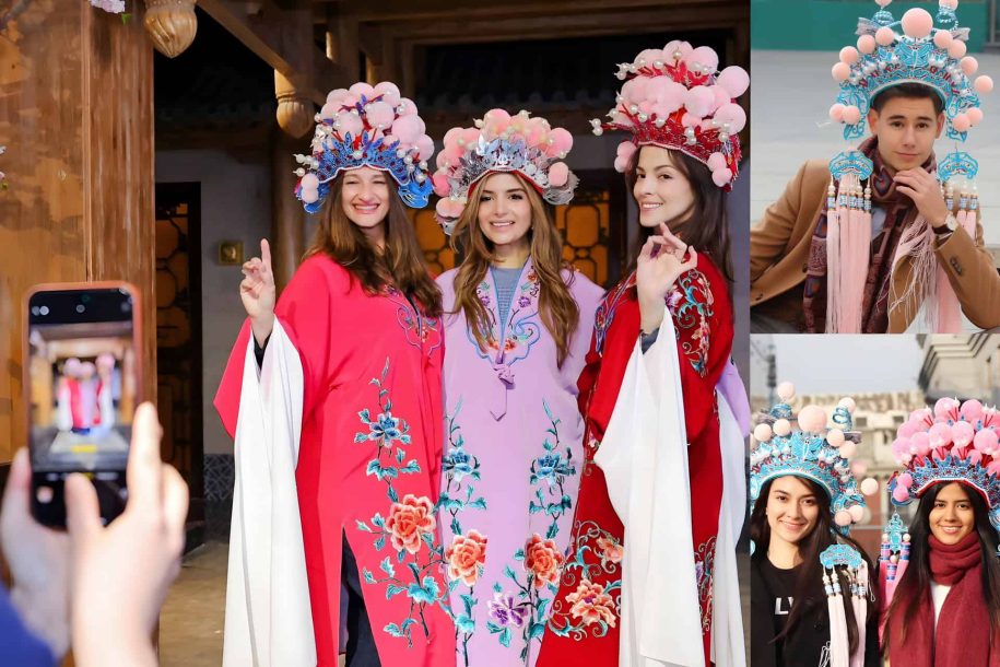 Audience member in elaborate Peking Opera costume and makeup posing for a souvenir photo at a theater