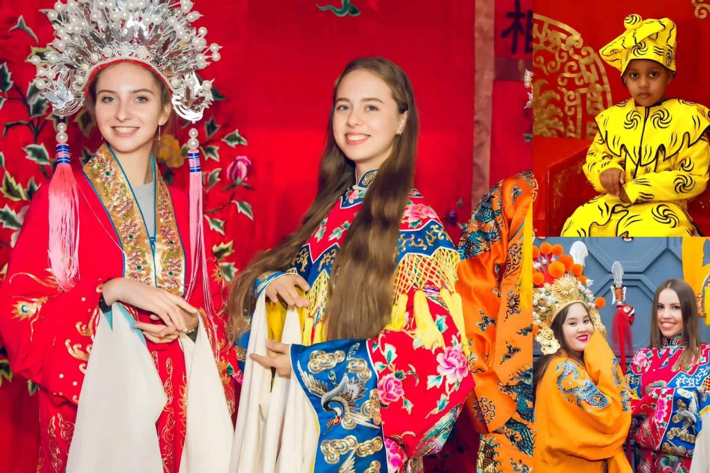 Audience member in elaborate Peking Opera costume and makeup posing for a souvenir photo at a theater