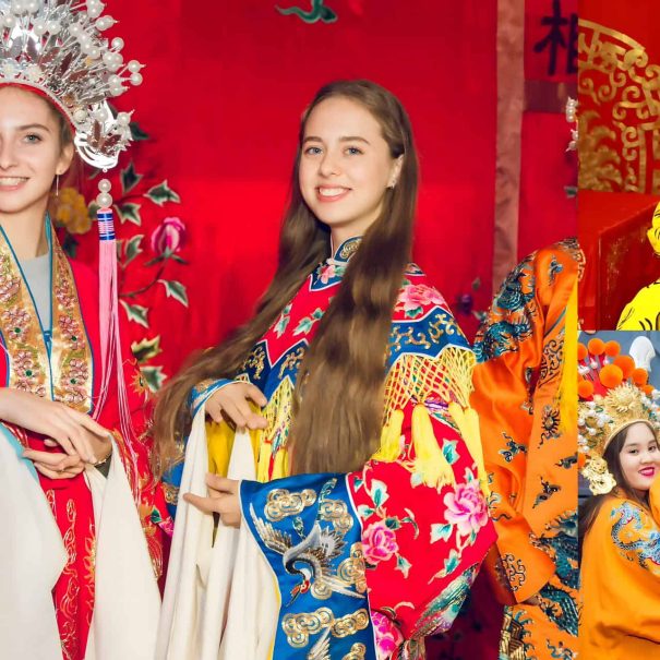 Audience member in elaborate Peking Opera costume and makeup posing for a souvenir photo at a theater
